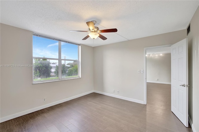 empty room featuring ceiling fan, hardwood / wood-style flooring, and a textured ceiling