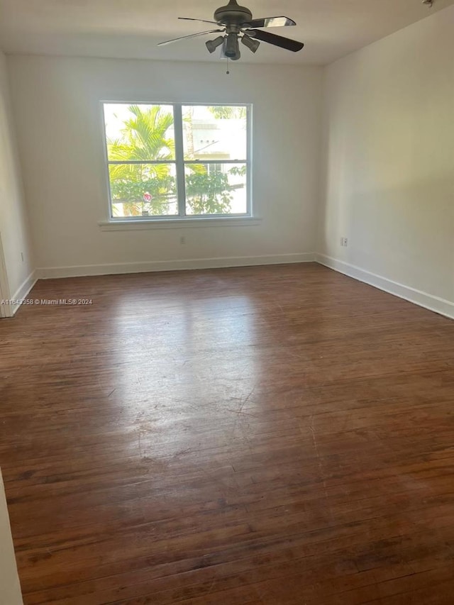 unfurnished room featuring ceiling fan and dark wood-type flooring