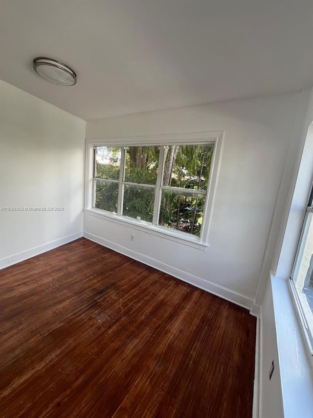 unfurnished room with hardwood / wood-style flooring and a healthy amount of sunlight