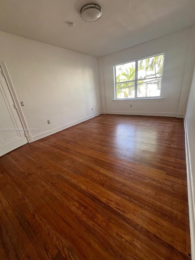 empty room with dark hardwood / wood-style flooring