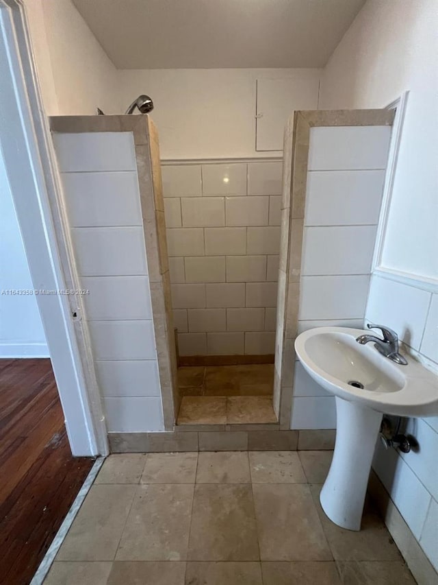 bathroom featuring a shower, tile patterned flooring, and tile walls