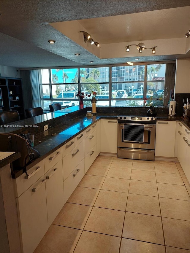 kitchen featuring plenty of natural light, light tile patterned floors, and electric range