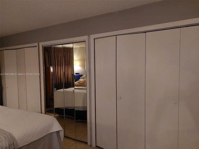 bedroom featuring multiple closets and light tile patterned flooring