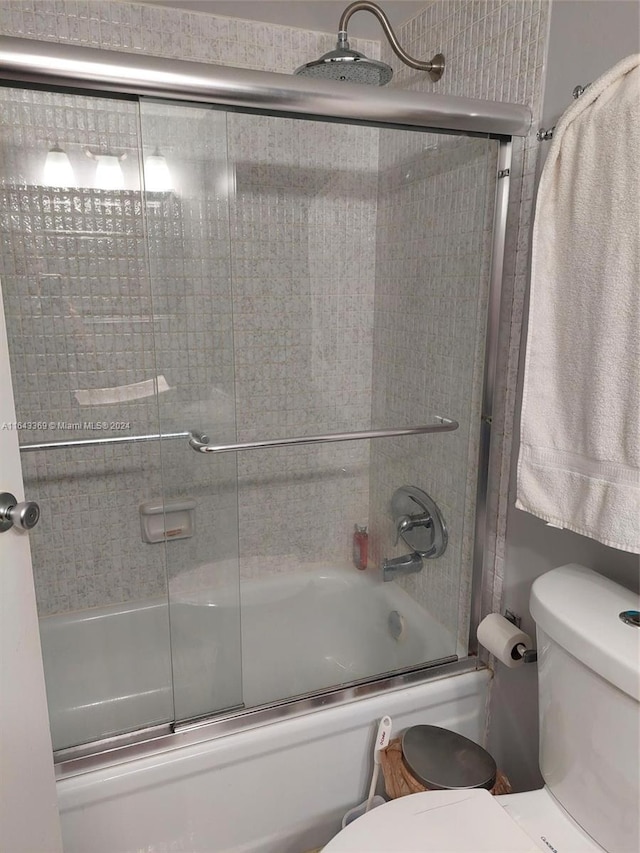 bathroom featuring shower / bath combination with glass door and toilet