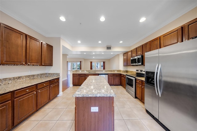 kitchen featuring a center island, crown molding, appliances with stainless steel finishes, light stone counters, and kitchen peninsula