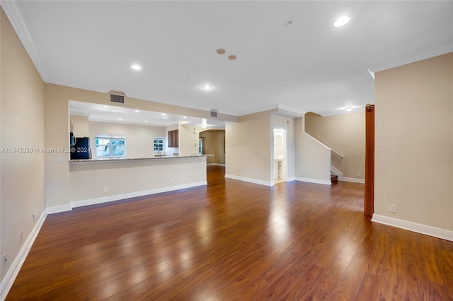 unfurnished living room with dark hardwood / wood-style flooring and ornamental molding