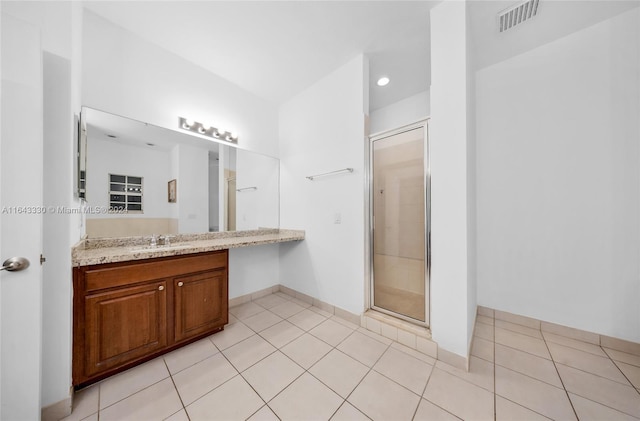 bathroom with tile patterned floors, vanity, and a shower with door