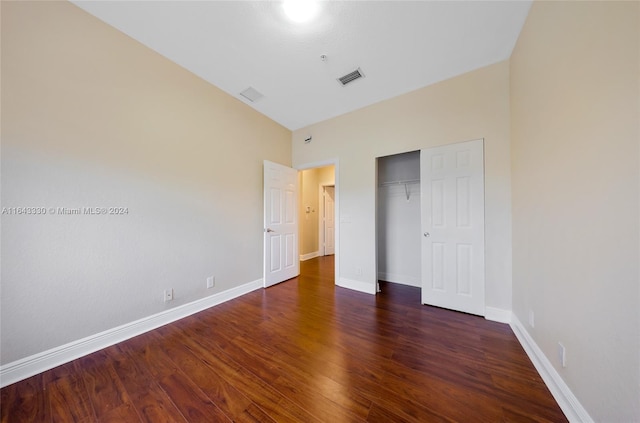 unfurnished bedroom with a closet and dark hardwood / wood-style floors