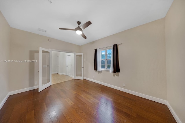 unfurnished bedroom with french doors, ceiling fan, and wood-type flooring