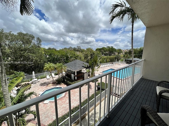 balcony with a fenced in pool and a patio area