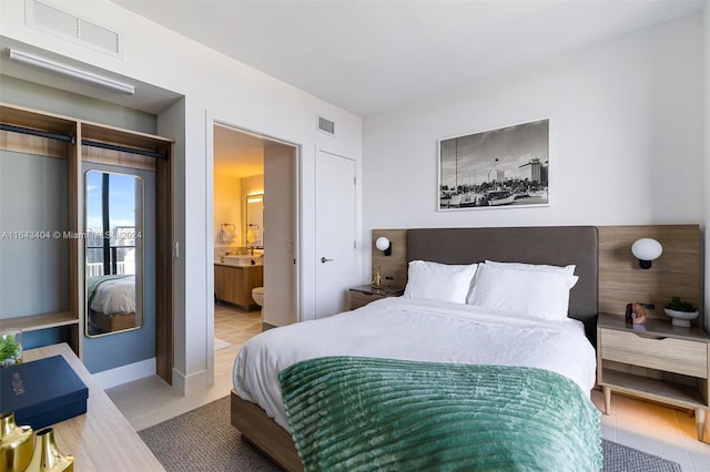 bedroom featuring light tile patterned floors and ensuite bath