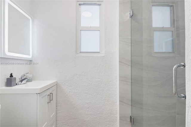 bathroom with a shower with door and vanity