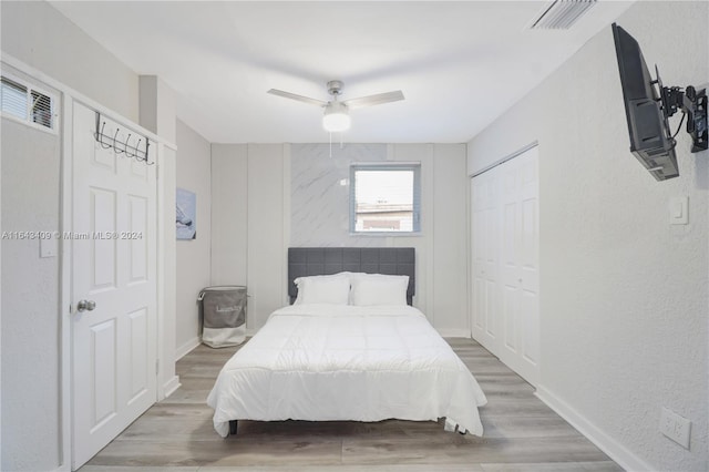 bedroom with ceiling fan, hardwood / wood-style flooring, and a closet