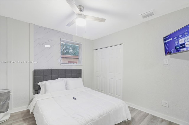 bedroom featuring ceiling fan, a closet, and light hardwood / wood-style floors