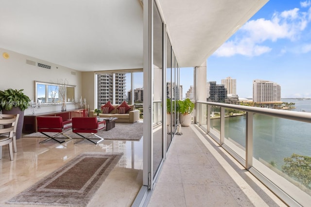 balcony with a view of city, an outdoor hangout area, and visible vents