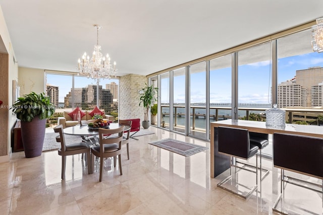 dining room with a wealth of natural light, a notable chandelier, a water view, and light tile patterned floors