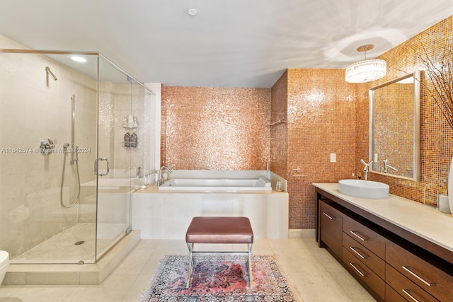 full bath featuring a stall shower, tile patterned flooring, a garden tub, and vanity