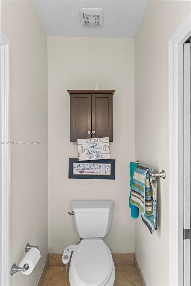 bathroom featuring toilet and tile patterned flooring