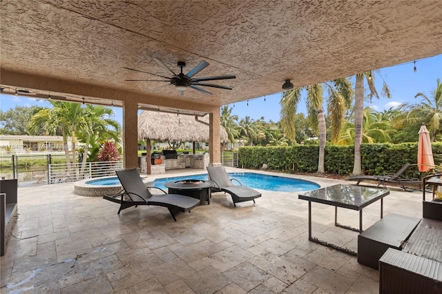 view of swimming pool with ceiling fan, an outdoor fire pit, and a patio