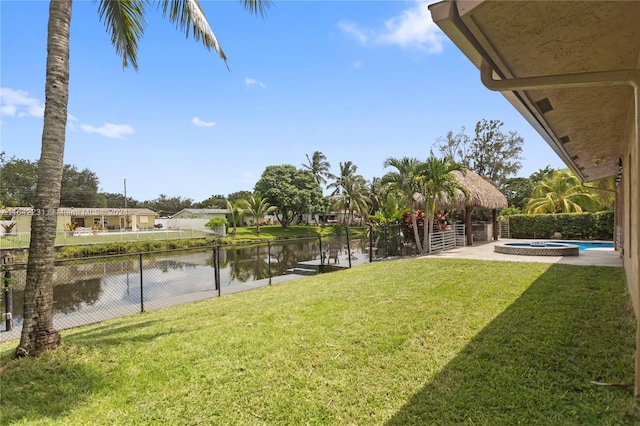 view of yard featuring a fenced in pool and a water view