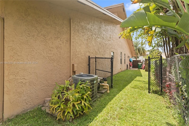 view of side of home featuring a lawn and central air condition unit