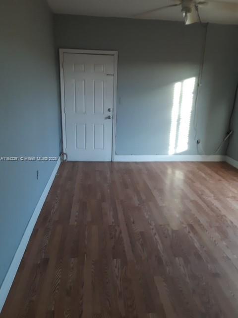 empty room featuring ceiling fan and dark hardwood / wood-style flooring