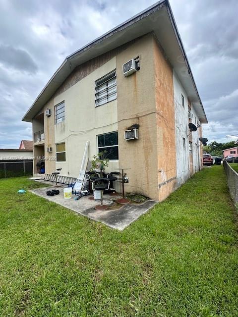 rear view of house with a patio and a yard