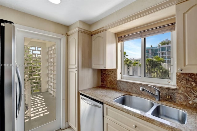 kitchen with backsplash, stainless steel appliances, sink, and light stone counters