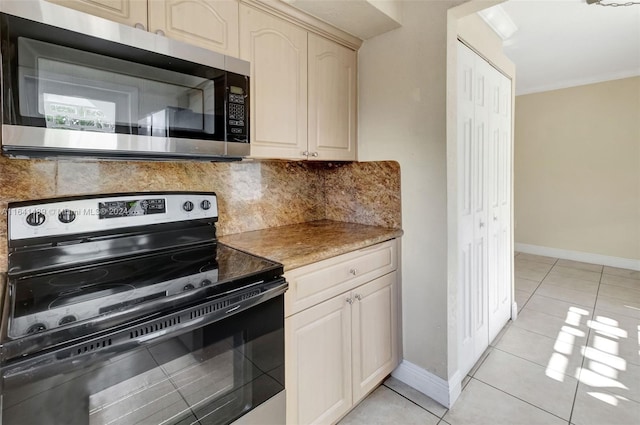 kitchen featuring ornamental molding, appliances with stainless steel finishes, decorative backsplash, cream cabinets, and light tile patterned floors