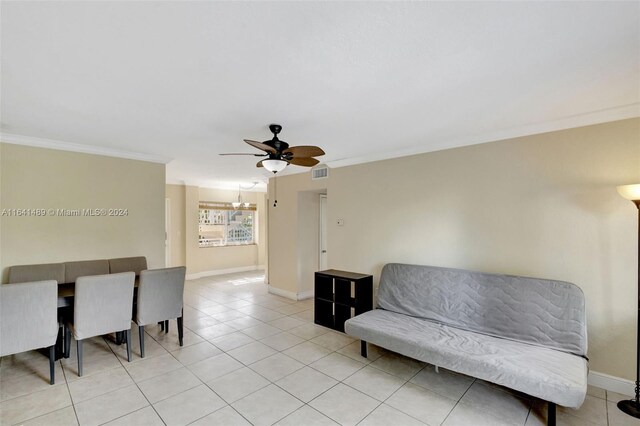 living area with ceiling fan, light tile patterned floors, and ornamental molding