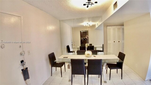 tiled dining area featuring a textured ceiling