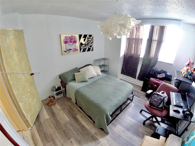 bedroom with a textured ceiling and hardwood / wood-style floors