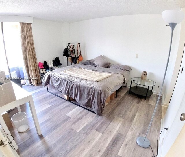 bedroom featuring a textured ceiling and light wood-type flooring