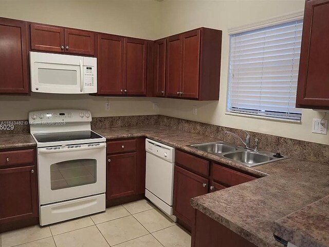 kitchen featuring white appliances, light tile patterned floors, and sink