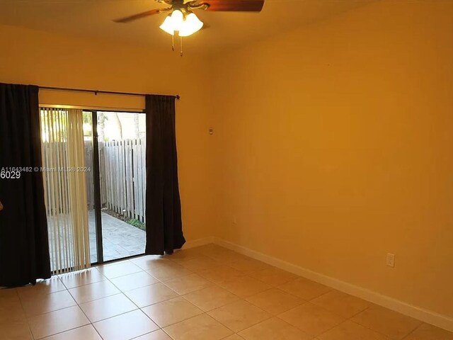 tiled spare room featuring ceiling fan