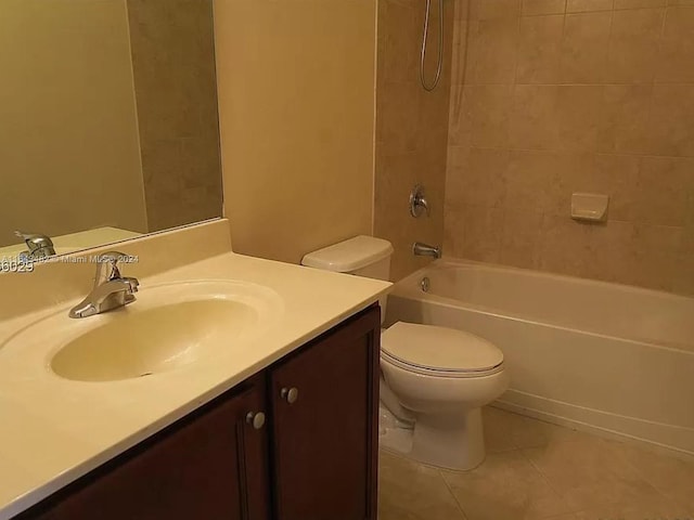 full bathroom featuring tile patterned flooring, vanity, tiled shower / bath, and toilet