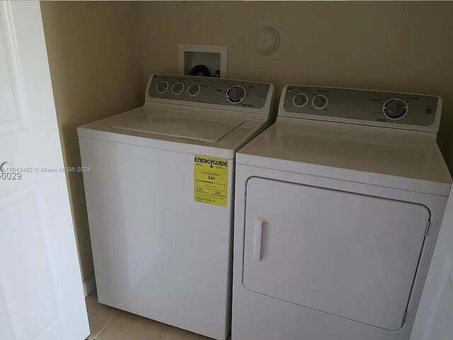 laundry room with washer and dryer and light tile patterned floors