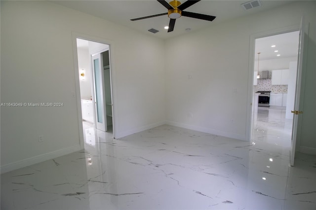 spare room with ceiling fan and light tile patterned floors