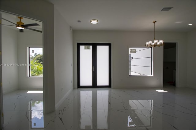 tiled spare room with ceiling fan with notable chandelier