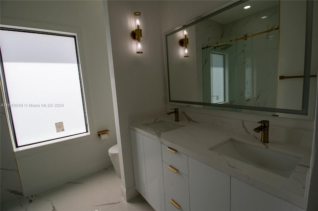 bathroom featuring a wealth of natural light, toilet, dual vanity, and tile patterned flooring