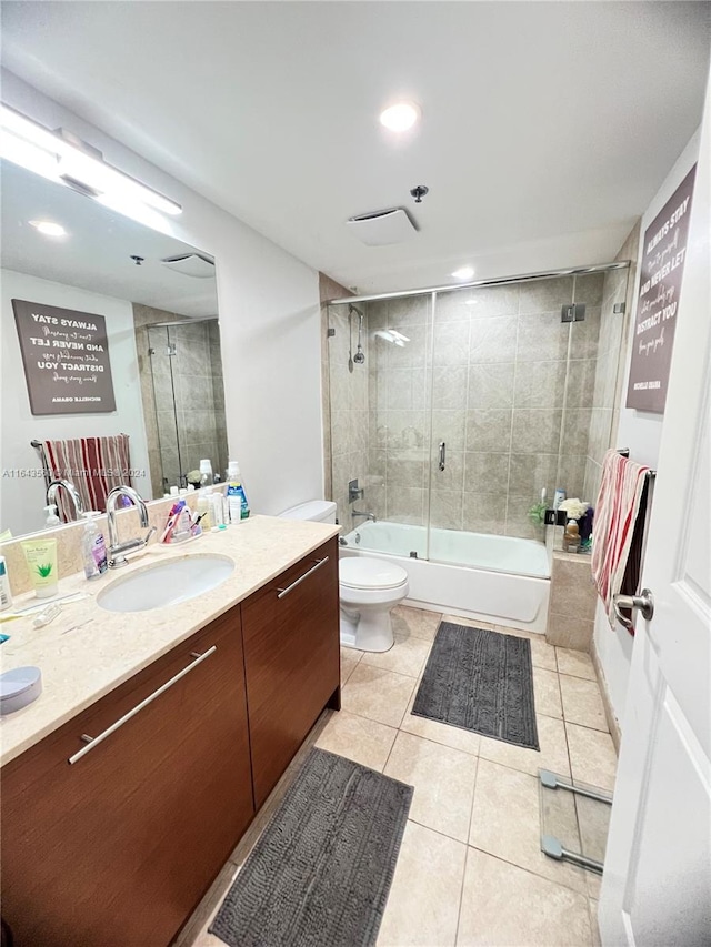 full bathroom featuring tile patterned floors, bath / shower combo with glass door, vanity, and toilet