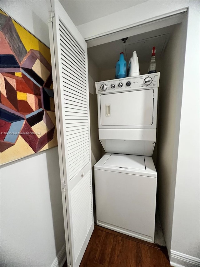 laundry area with stacked washer and dryer and dark hardwood / wood-style flooring