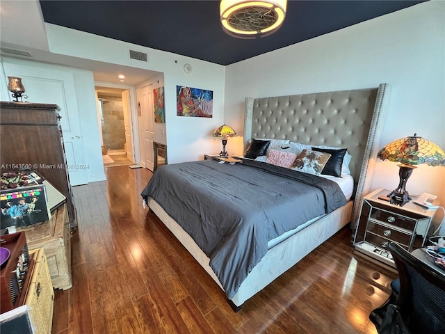 bedroom with dark hardwood / wood-style flooring and ensuite bathroom