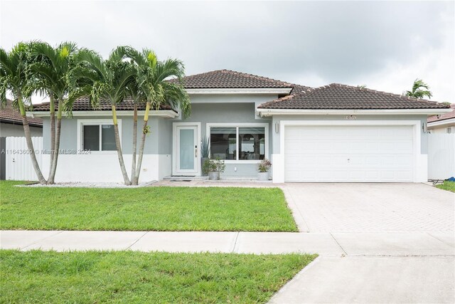 view of front of home with a garage and a front lawn