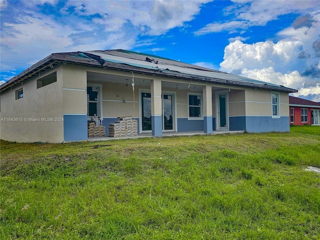 back of house featuring a lawn