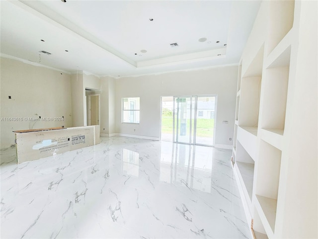 unfurnished living room featuring a tray ceiling and light tile patterned floors