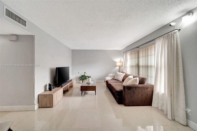 living room featuring a textured ceiling and light tile patterned floors