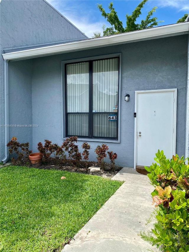 doorway to property featuring a lawn