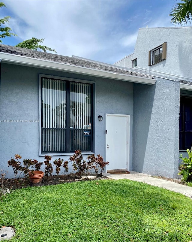 doorway to property with a yard