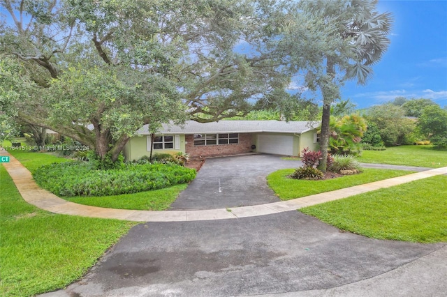 single story home featuring a garage and a front yard